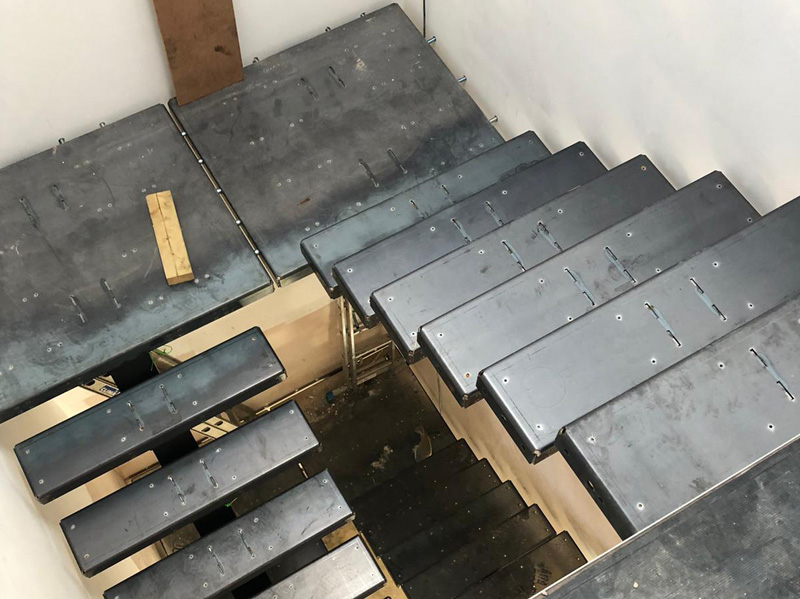 Steel staircase carcass with treads being fitted on site