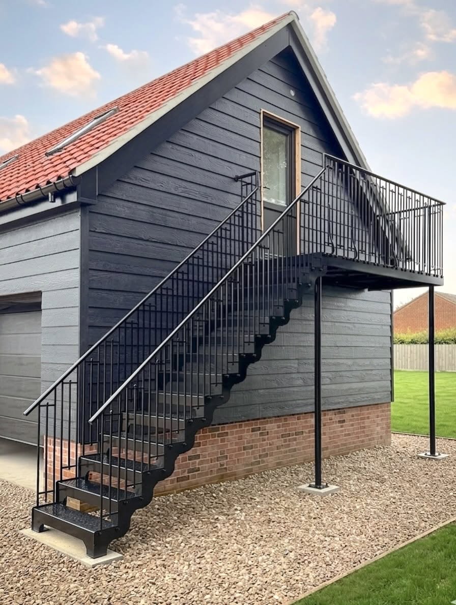 External steel staircase with decorative perforated tray treads and shaped strings
